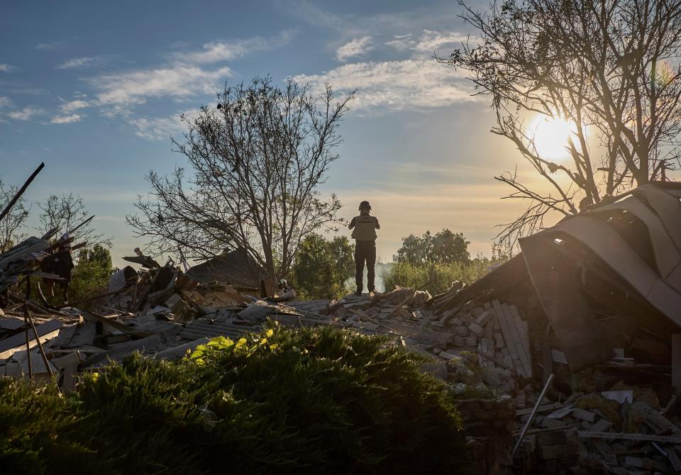 A Ukrainian policeman stands at the site of a glide bomb attack on a private building in Vilkhivka village near Kharkiv (EPA)