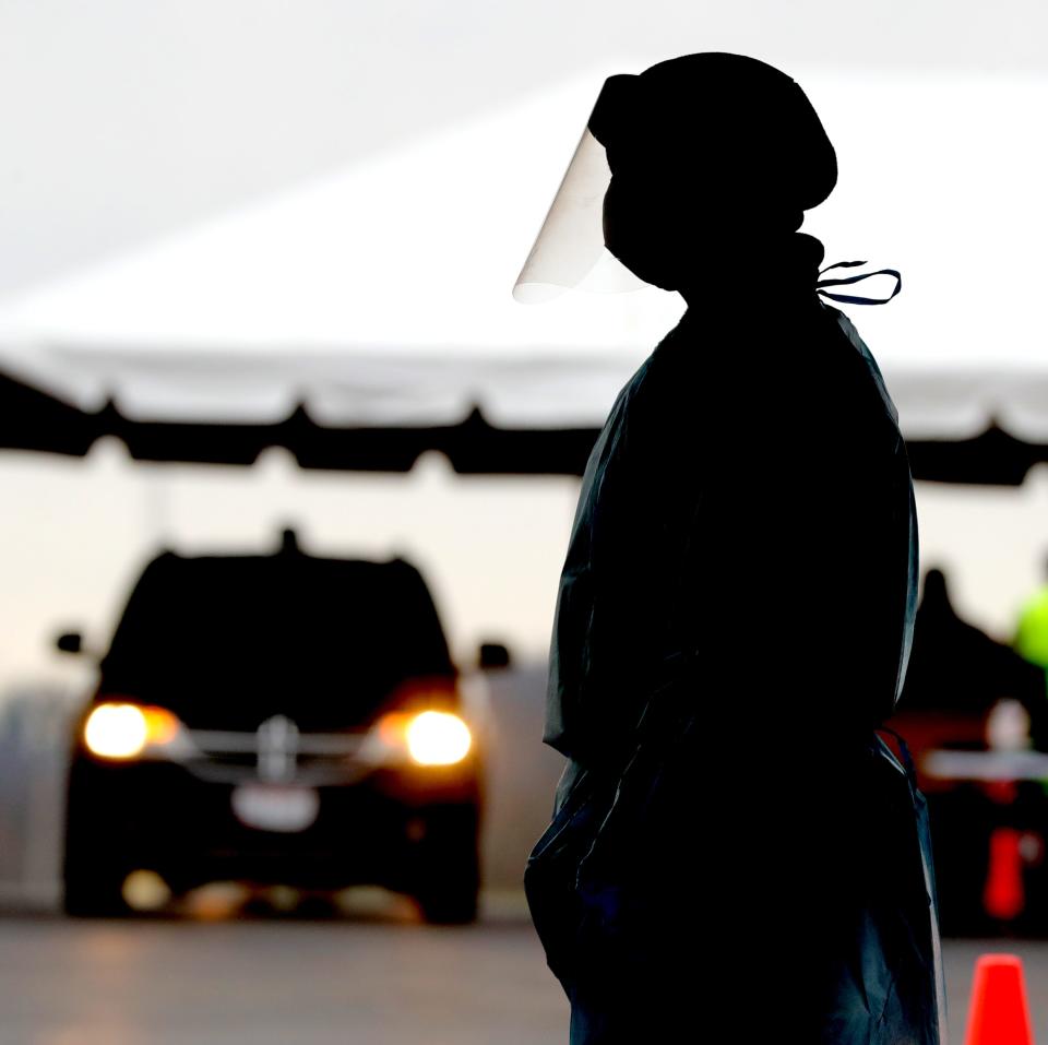 A member of the Ohio National Guard waits for a car to finish the registration process at the drive-up COVID testing site behind the corporate offices of Summa Health on Gorge Boulevard in Akron.