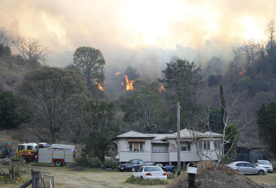 Fire and Emergency crew battle bushfire near a house in the rural town of Canungra in the Scenic Rim region of South East Queensland.