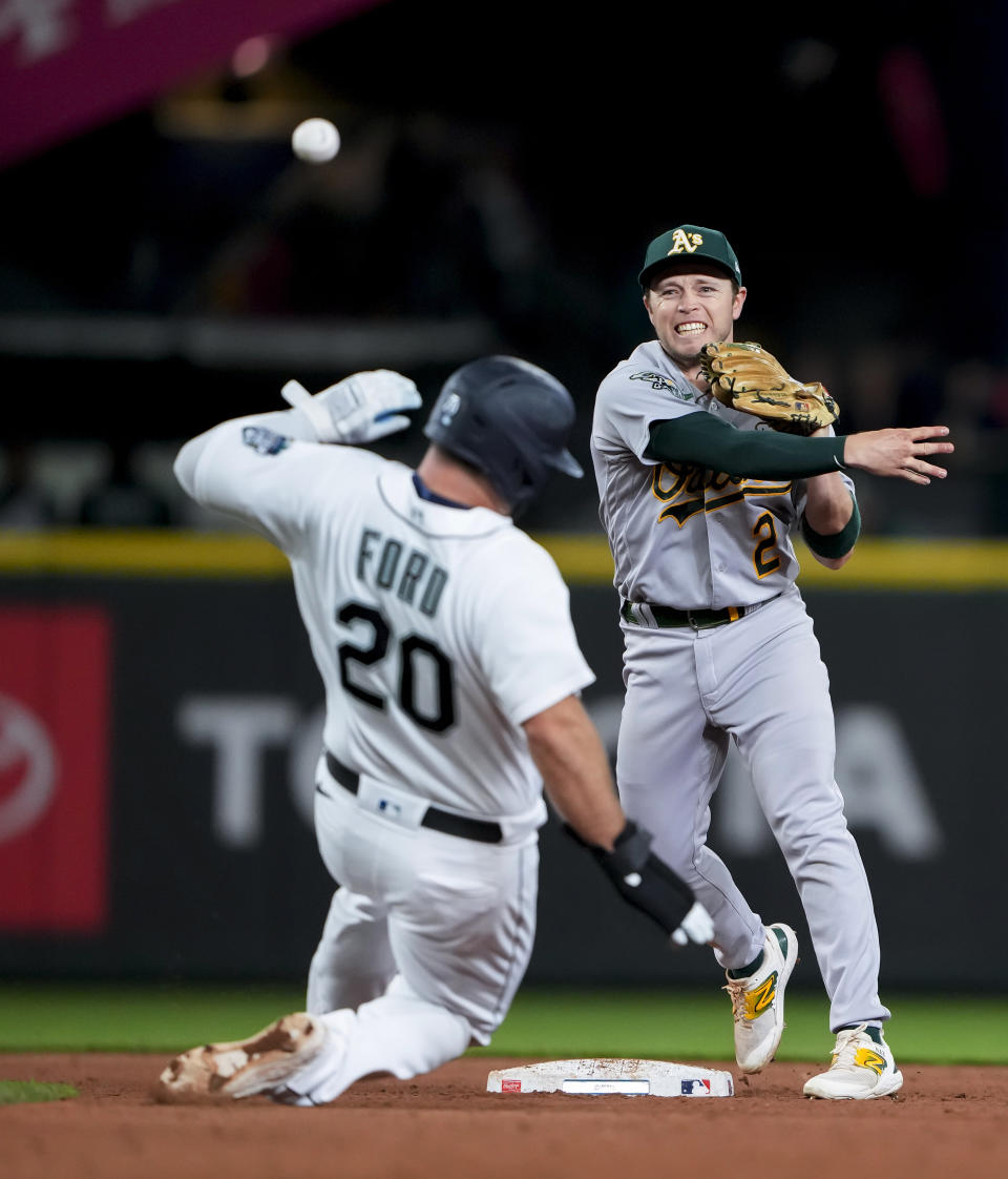 Oakland Athletics shortstop Nick Allen throws to first after forcing out Seattle Mariners' Mike Ford at second base on a ball hit by Dylan Moore, who was safe at first during the sixth inning of a baseball game Tuesday, Aug. 29, 2023, in Seattle. (AP Photo/Lindsey Wasson)