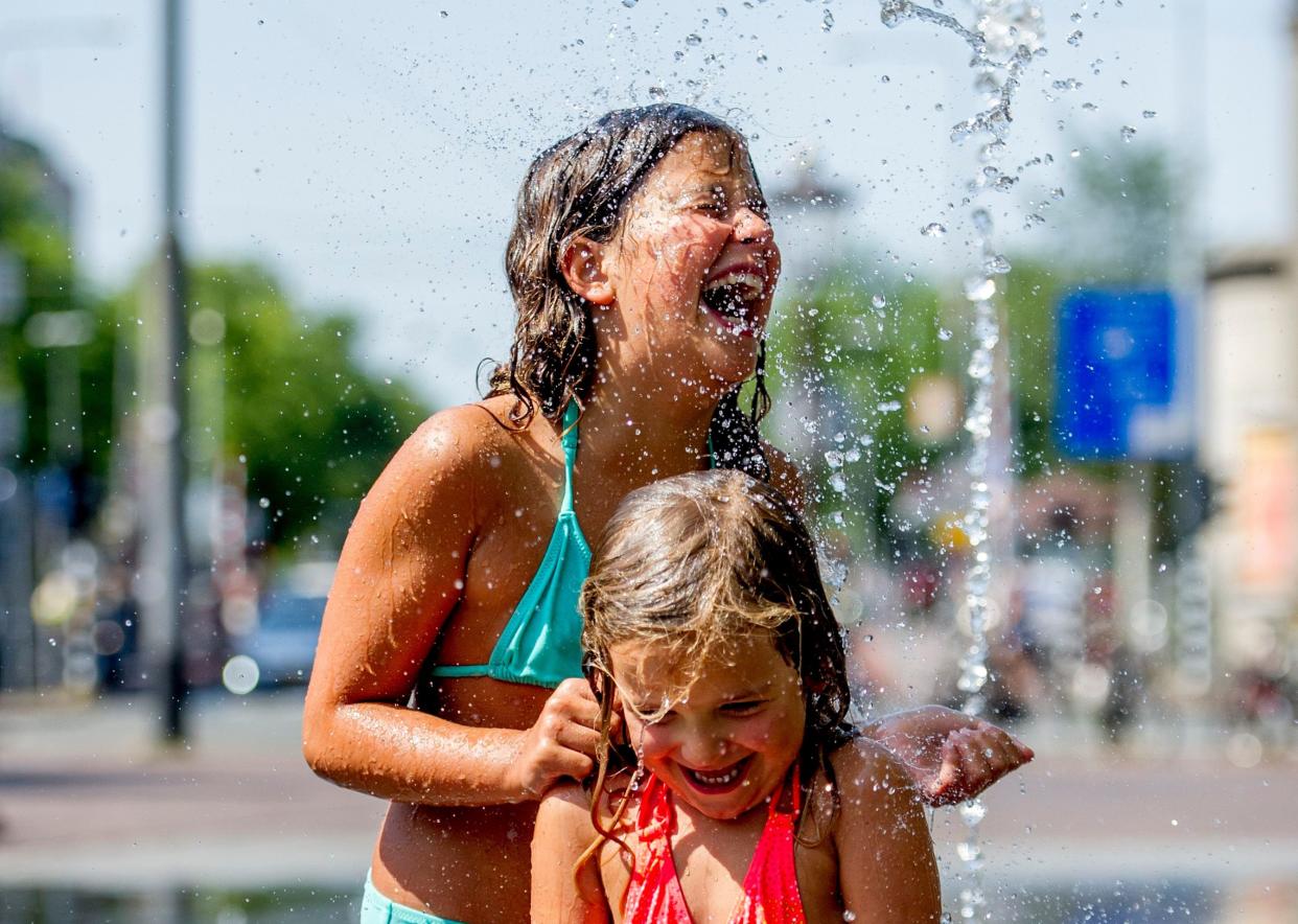 People cool off in a fountain in Amsterdam (Getty)