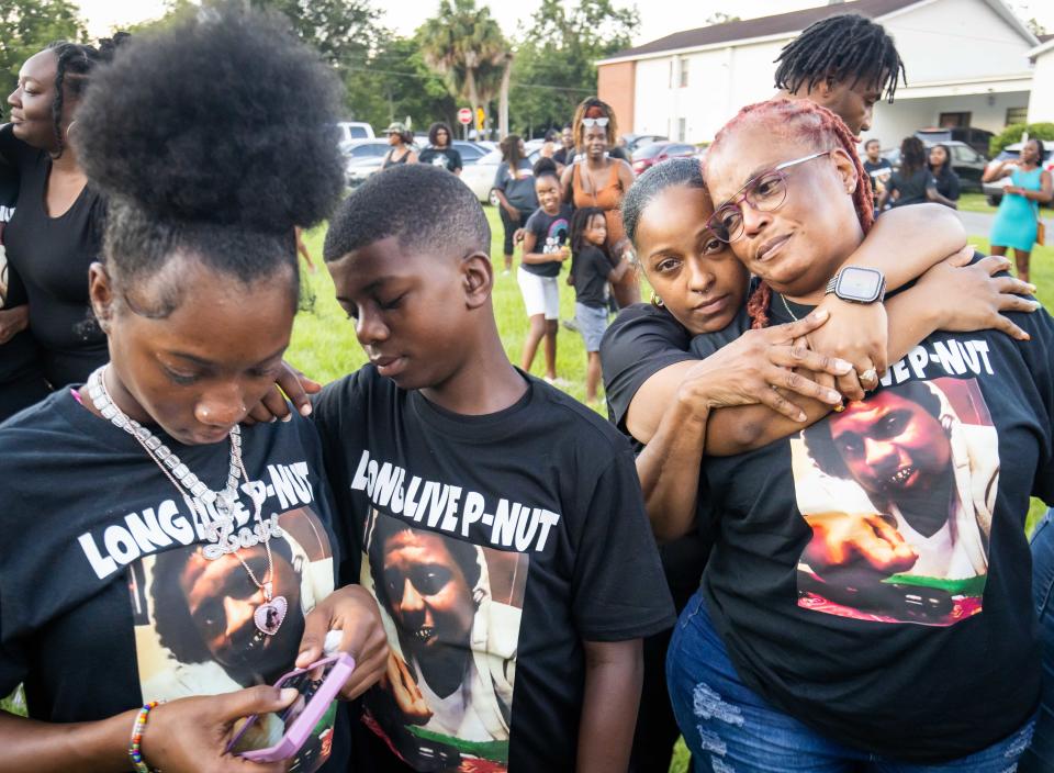 Near Miller, second from right, hugs and consoles her Aunt Phylliss Mulkey Thursday during the balloon release honoring Mulkey's son, who was killed last weekend in Gainesville. War Cry 4 Peace held the prayer vigil and balloon release for Ronnie "P nut" James Jr. of Ocala at St. Paul AME Church in Ocala. About 300 people attended the vigil.