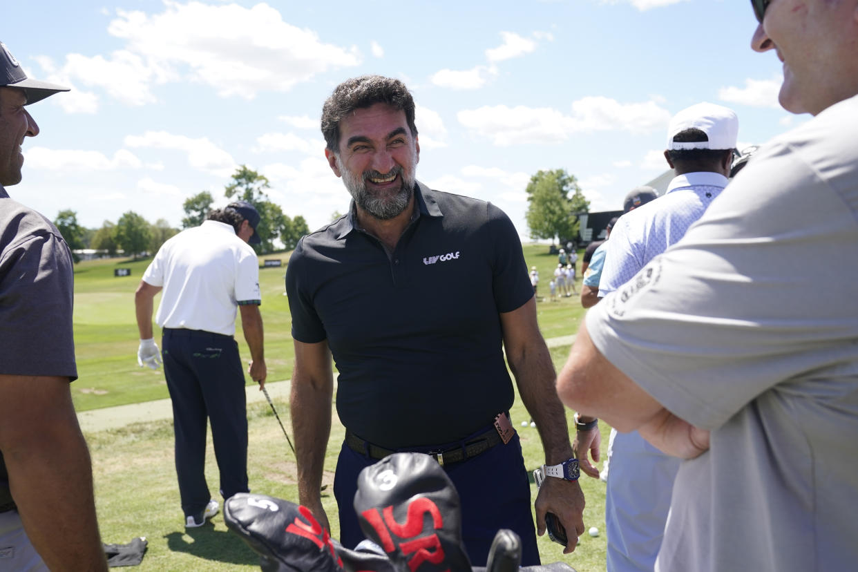 Yasir Al-Rumayyan, governor of Saudi Arabia's Public Investment Fund, laughs while greeting golfers at the range before the start of the second round of the Bedminster Invitational LIV Golf tournament in Bedminster, N.J., Saturday, July 30, 2022. (AP Photo/Seth Wenig)