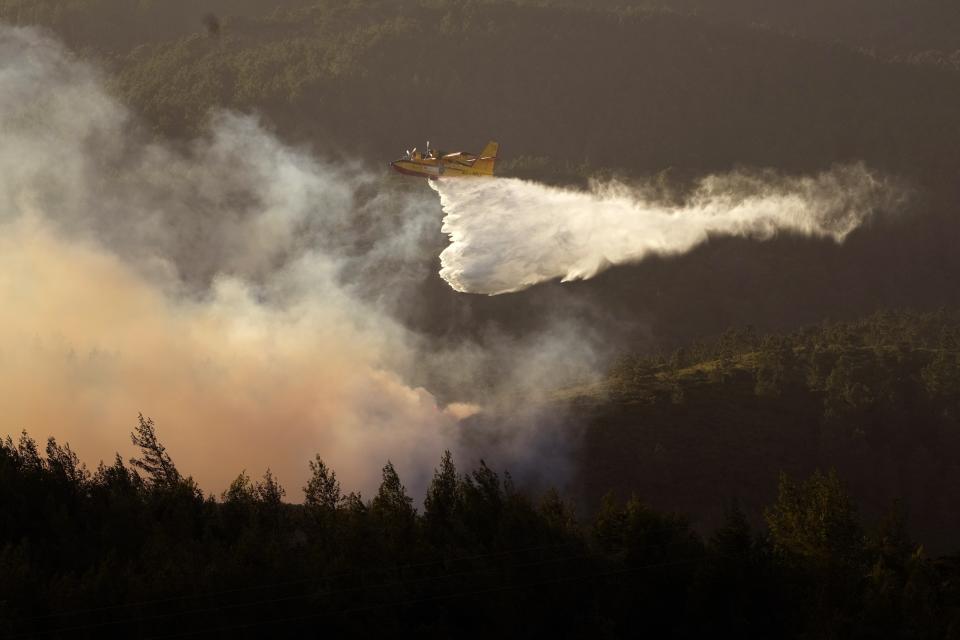 FILE - A seaplane discharges water on the flames as the fire advances in Alcabideche, outside Lisbon on July 25, 2023. Six young people from Portugal are arguing on Wednesday, Sept. 27, that governments across Europe aren't doing enough to protect people from the harms of climate change at the European Court of Human Rights. (AP Photo/Armando Franca, File)