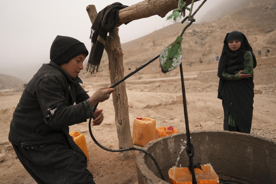 An Afghan boy pulls improvised bucket of water out of the well in Balucha, Afghanistan, Monday, Dec. 13, 2021. Severe drought has dramatically worsened the already desperate situation in Afghanistan forcing thousands of people to flee their homes and live in extreme poverty. Experts predict climate change is making such events even more severe and frequent. (AP Photo/Mstyslav Chernov)