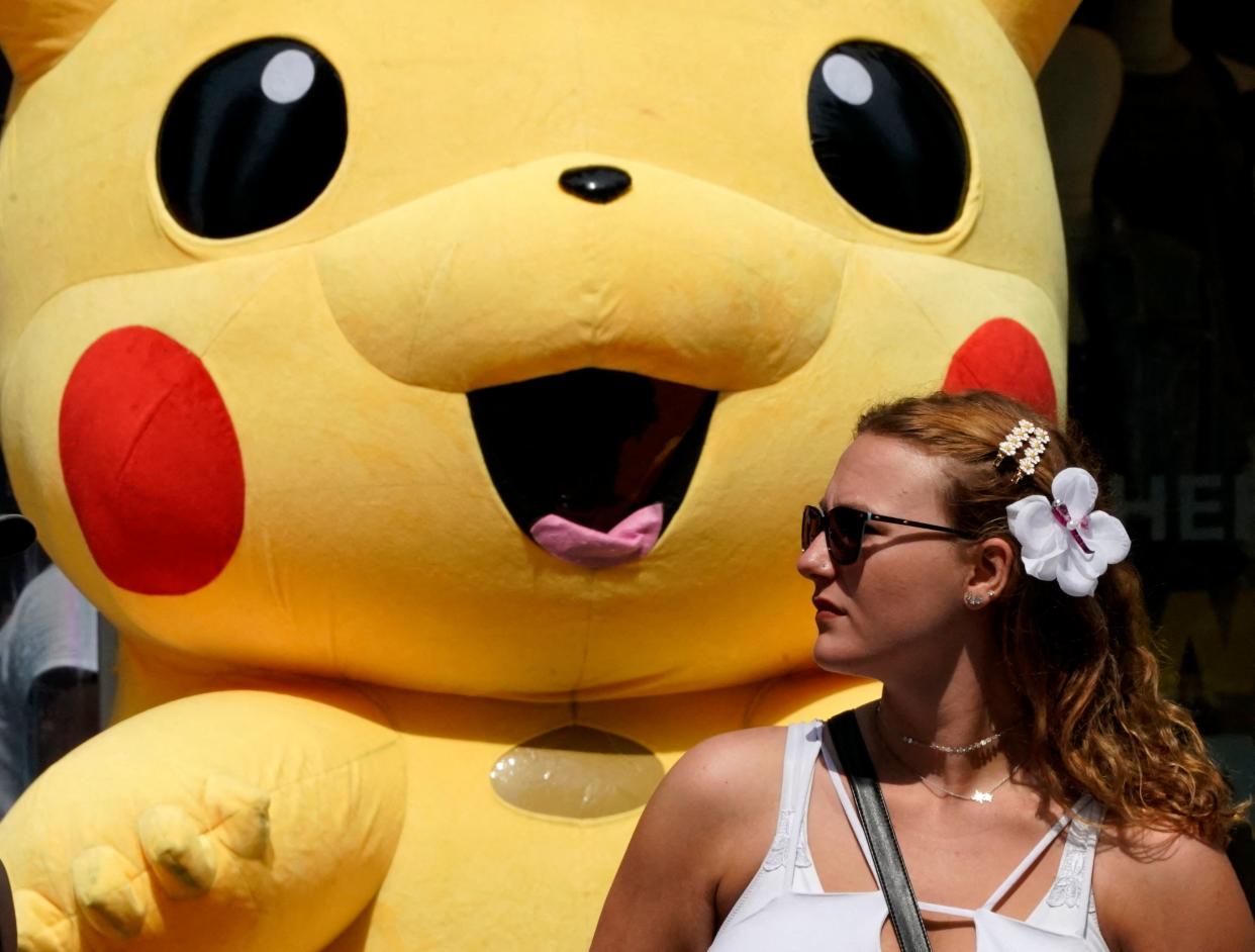 A person walks past a Pikachu mascot at Times Square on July 22, 2021, as the Delta Covid surge is renewing calls for mask mandates in New York. - New York City will require public hospital workers to get vaccinated or take a weekly coronavirus test, Mayor Bill de Blasio said on July 21, as the metropolis faces an uptick in cases fueled by the Delta variant. (Photo by TIMOTHY A. CLARY / AFP) (Photo by TIMOTHY A. CLARY/AFP via Getty Images)