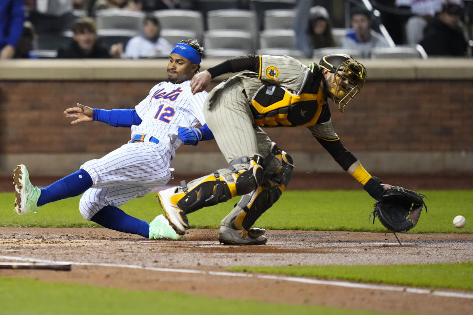 New York Mets' Francisco Lindor, left, slides past San Diego Padres catcher Austin Nola to score on a two-run double by Jeff McNeil during the third inning of a baseball game Monday, April 10, 2023, in New York. (AP Photo/Frank Franklin II)