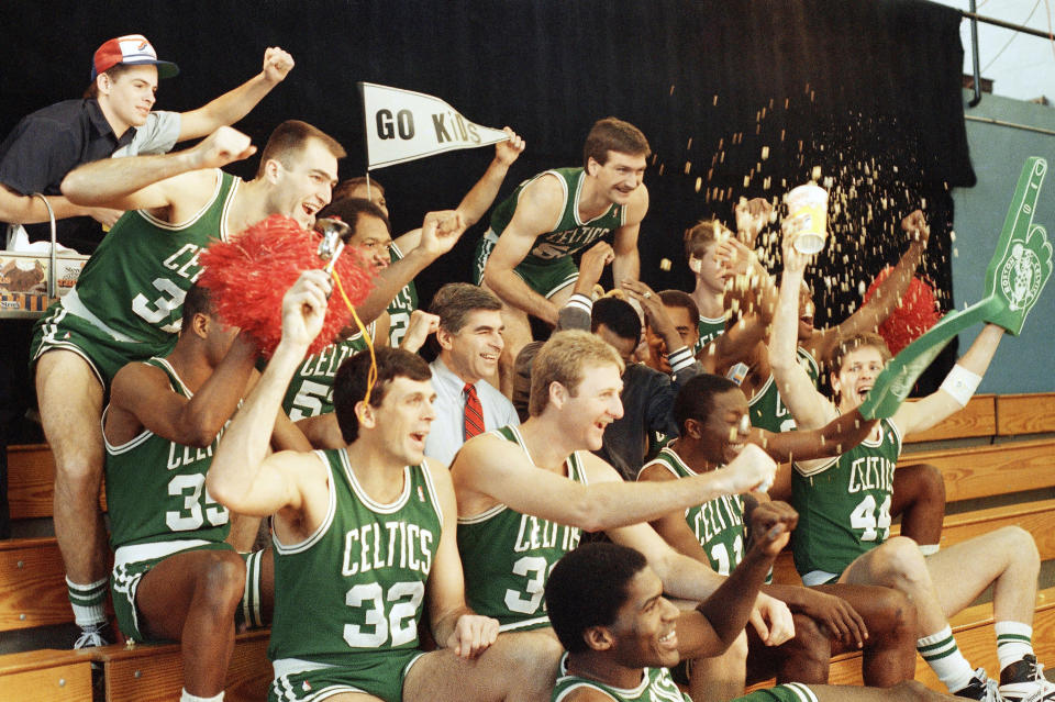 Massachusetts Governor Michael S. Dukakis, center, cheers with the Boston Celtics on Thursday, Jan. 15, 1988, in Brookline, Massachusetts during a taping of an anti-drug and alcohol video for anti-drug school program. Dukakis is surrounded by Celtics Fred Roberts, upper-left; Kelvin McHale; lower left and Larry Bird, with Greg Kite, upper-right and Artis Gilmore seated behind Dukakis at Hellenic College in Brookline, Mass. (AP Photo/Carol Francavilla)