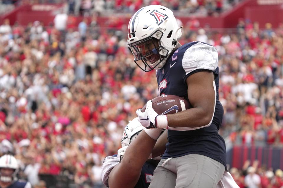 Arizona running back Michael Wiley celebrates after scoring a touchdown against Utah during the first half of an NCAA college football game, Saturday, Nov. 18, 2023, in Tucson, Ariz. | Rick Scuteri, Associated Press