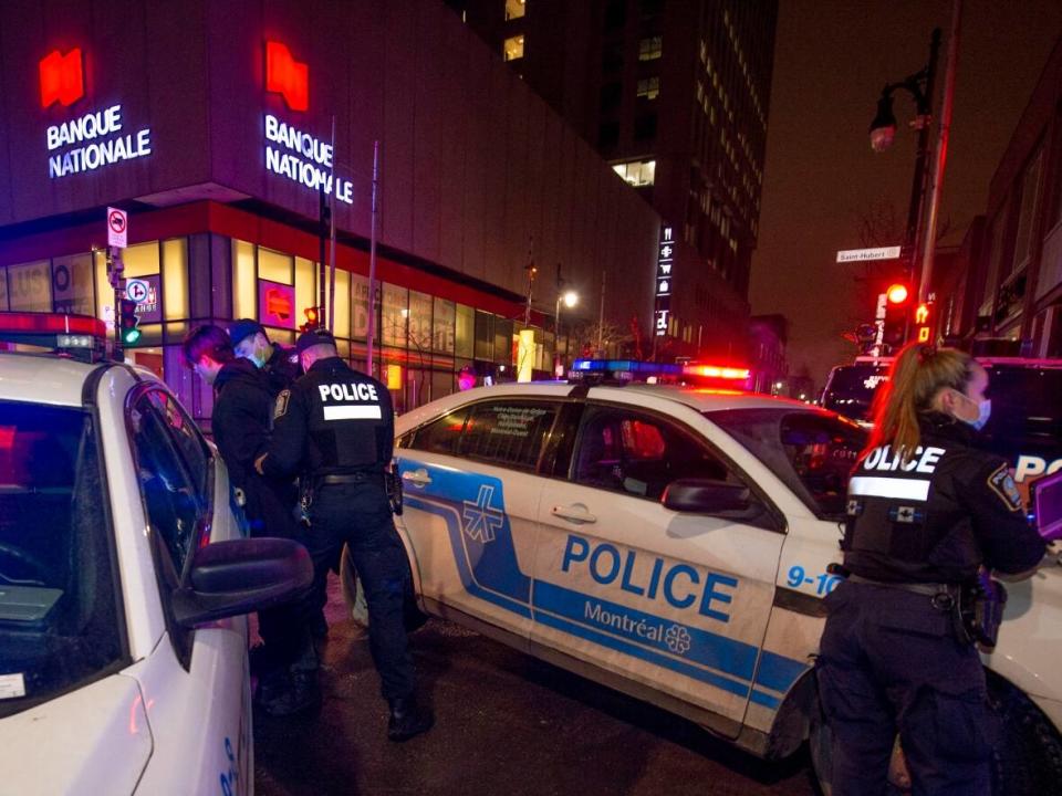 Police detain a man in Montreal who ran from them at the start of a curfew in Quebec on Dec. 31, 2021. The 10 p.m. to 5 a.m. curfew is intended to help stem the rise of COVID-19 infections. (Peter McCabe/The Canadian Press - image credit)