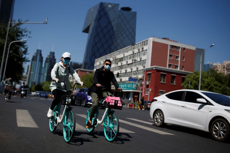People wearing protective masks ride bikes in the Central Business District on a “blue sky day" in Beijing as the spread of the novel coronavirus disease (COVID-19) continues
