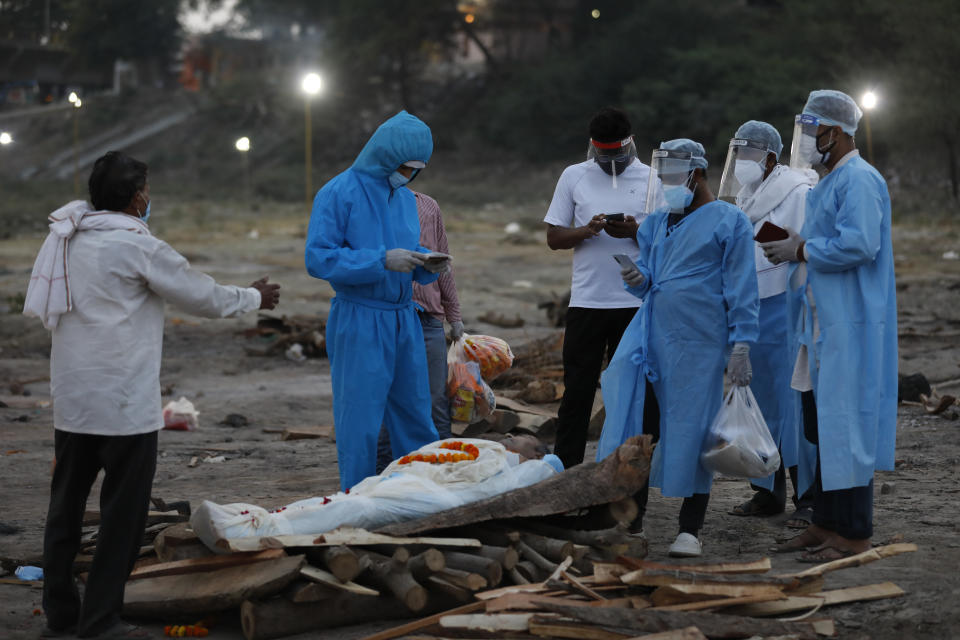 Family members pay last respect to their relative Rajendra Prasad Mishra, a 62-year-old man who has lost his life from coronavirus infection before cremation at River Ganges at Phaphamau in Prayagraj, India, Saturday, May 8, 2021. (AP Photo/Rajesh Kumar Singh)