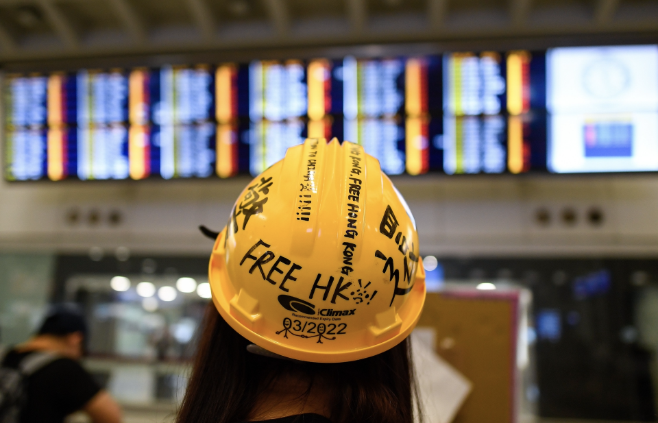 A Pro-Democracy protester looks at the flight information board showing cancelled flights following a protest against police brutality and the controversial extradition bill at Hong Kong's international airport on August 12, 2019. (Photo: MANAN VATSYAYANA/AFP/Getty Images) 