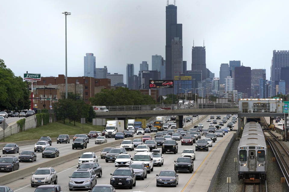 FILE - Motorists head southbound in the local and express lanes on Interstates 90-94 in slow and thickening traffic as a CTA train enters a station on the first day of the Fourth of July holiday weekend, July 1, 2022, in Chicago. Millions of Americans are preparing to get out of town sometime in the coming Fourth of July holiday week, which will likely mean busy roads as well as packed airports and train stations. (AP Photo/Charles Rex Arbogast, File)