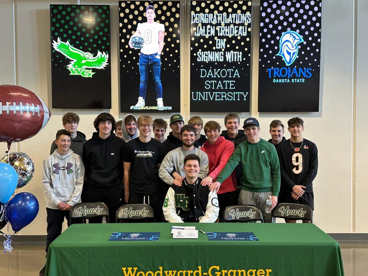 Jalen Trudeau poses for a photo with his Woodward-Granger football teammates after committing to play football for Dakota State on Wednesday, Feb. 1, 2023.