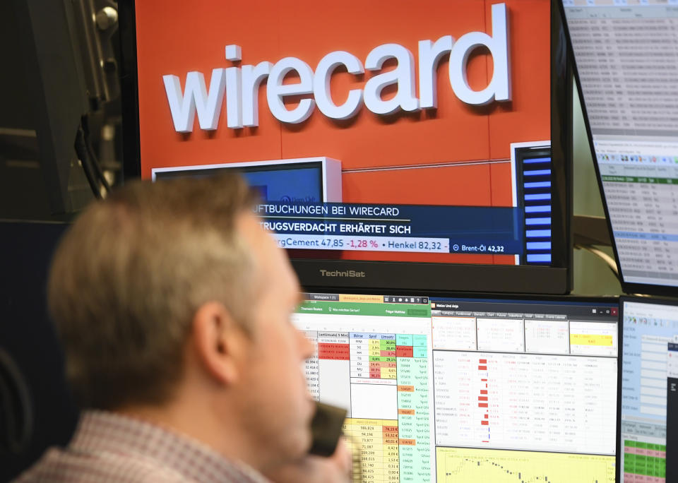 A stockbroker sits in front of a screen with news about the payment service provider Wirecard at the Frankfurt Stock Exchange in Frankfurt, Germany, Monday, June 22, 2020. Germany payment service provider Wirecard AG says it has concluded that two accounts that were supposed to contain 1.9 billion euros (2.1 billion dollars) probably don’t exist. (Arne Dedert/dpa via AP)