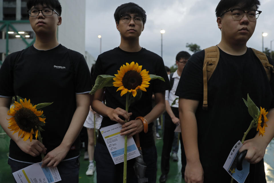 Attendees take part in a public memorial for Marco Leung, the 35-year-old man who fell to his death weeks ago after hanging a protest banner against an extradition bill, in Hong Kong, Thursday, July 11, 2019. The parents of Leung have urged young people to stay alive to continue their struggle. (AP Photo/Kin Cheung)