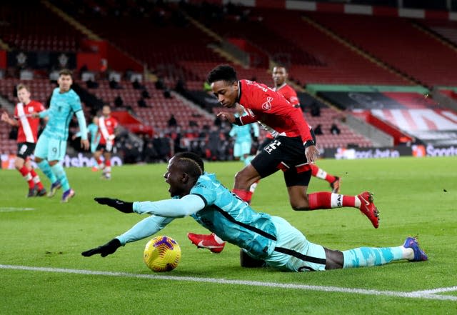 Liverpool forward Sadio Mane falls in the penalty area under a challenge from Southampton's Kyle Walker-Pieters