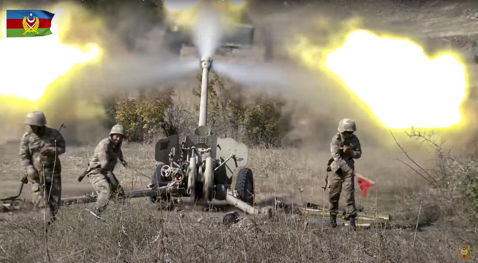 In this image taken from video released by Azerbaijan's Defense Ministry on Tuesday, Oct. 20, 2020, Azerbaijan army soldiers fire an artillery piece during fighting with forces of the self-proclaimed Republic of Nagorno-Karabakh. Azerbaijan Defense Ministry claims that Armenian forces tried to carry out an offensive that was met by an artillery strike from Azerbaijan, causing a large number of casualties among Armenian forces. (Azerbaijan's Defense Ministry via AP)