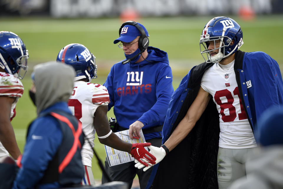 New York Giants offensive coordinator Jason Garrett, center, greets players on the sideline after a touchdown against the Baltimore Ravens during the second half of an NFL football game, Sunday, Dec. 27, 2020, in Baltimore. (AP Photo/Gail Burton)