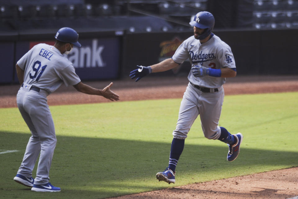 Los Angeles Dodgers' Chris Taylor is congratulated by Dino Ebel after hitting a solo home run off San Diego Padres relief pitcher Garrett Richards during the sixth inning of a baseball game Wednesday, Sept. 16, 2020, in San Diego. (AP Photo/Derrick Tuskan)