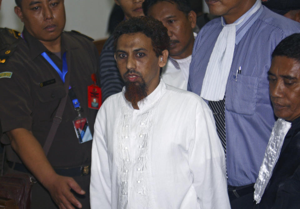 File - Indonesian Muslim militant Umar Patek is escorted by prosecutors and plain-clothed police officers as he leaves the courtroom after his hearing at West Jakarta district court in Jakarta, Indonesia, Monday, May 21, 2012. A bombmaker in the 2002 Bali attack that killed 202 people has walked free from an Indonesian prison Wednesday, Dec. 7, 2022 after serving half of a 20-year sentence, despite upsetting Australia’s leader who described him as “abhorrent.” Umar Patek, 55, whose real name is Hisyam bin Alizein, was a leading member of the al Qaida-linked network Jemaah Islamiyah. (AP Photo/Tatan Syuflana, File)