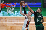 Boston Celtics guard Evan Fournier (94) tries to block a shot by Miami Heat guard Tyler Herro during the second half of an NBA basketball game Tuesday, May 11, 2021, in Boston. (AP Photo/Charles Krupa)