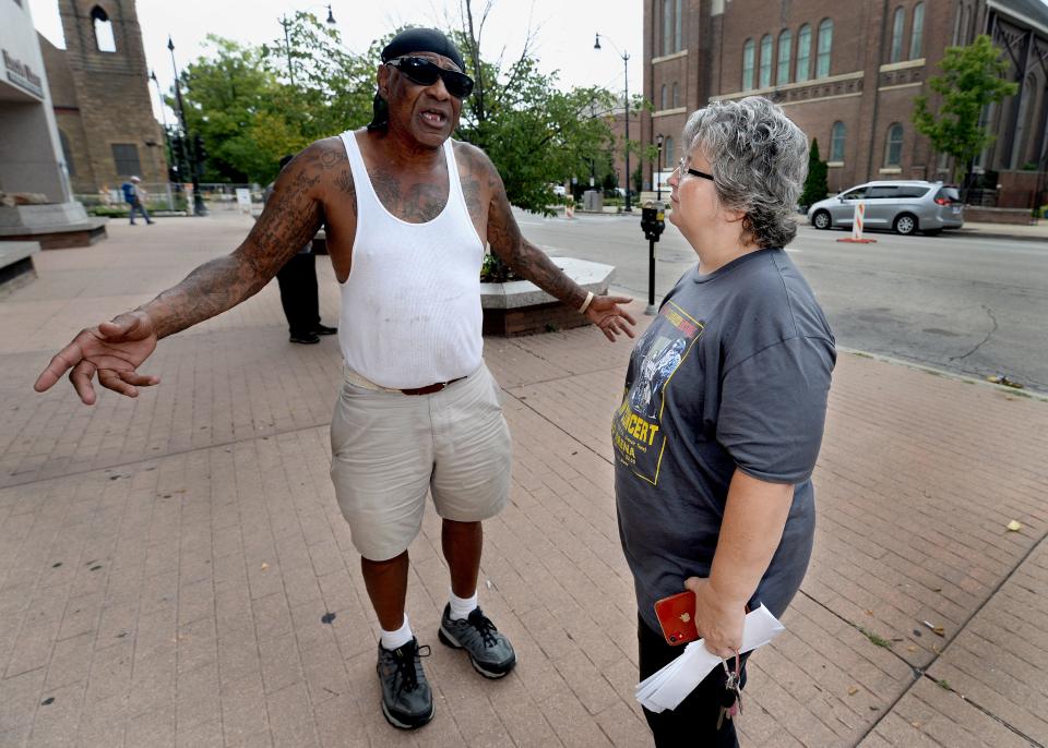 Charles Miller of Springfield, left, talks with homeless advocate Julie Benson in front of the Lincoln Library on Thursday, July 7, 2022. At 65, Miller said he is homeless for the first time in his life after he losing his job when the restaurant he was working at shut down because of the COVID-19 pandemic. Miller said Benson has been a godsend, bringing coats, blankets and food those homeless people who need it. Benson was recognized by the national Sertoma service organization recently.