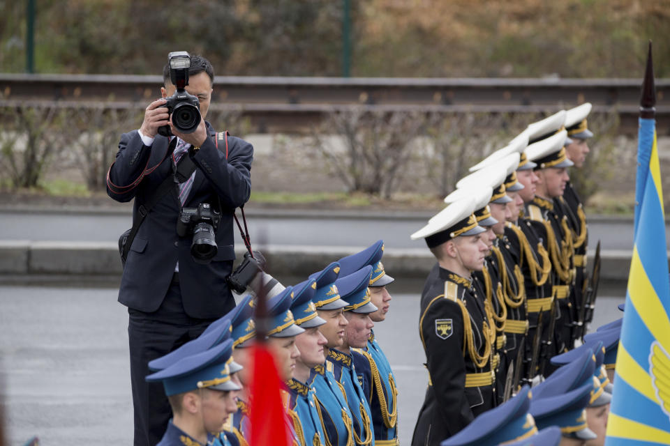 North Korean photographer takes pictures of honor guards before a wreath-laying ceremony in Vladivostok, Russia, Friday, April 26, 2019. North Korean leader Kim Jong Un paid his respects at a ceremony honoring the war dead Friday to wrap up a brief and generally successful visit to the Russian Far East for his first summit with President Vladimir Putin. (AP Photo/Alexander Khitrov)