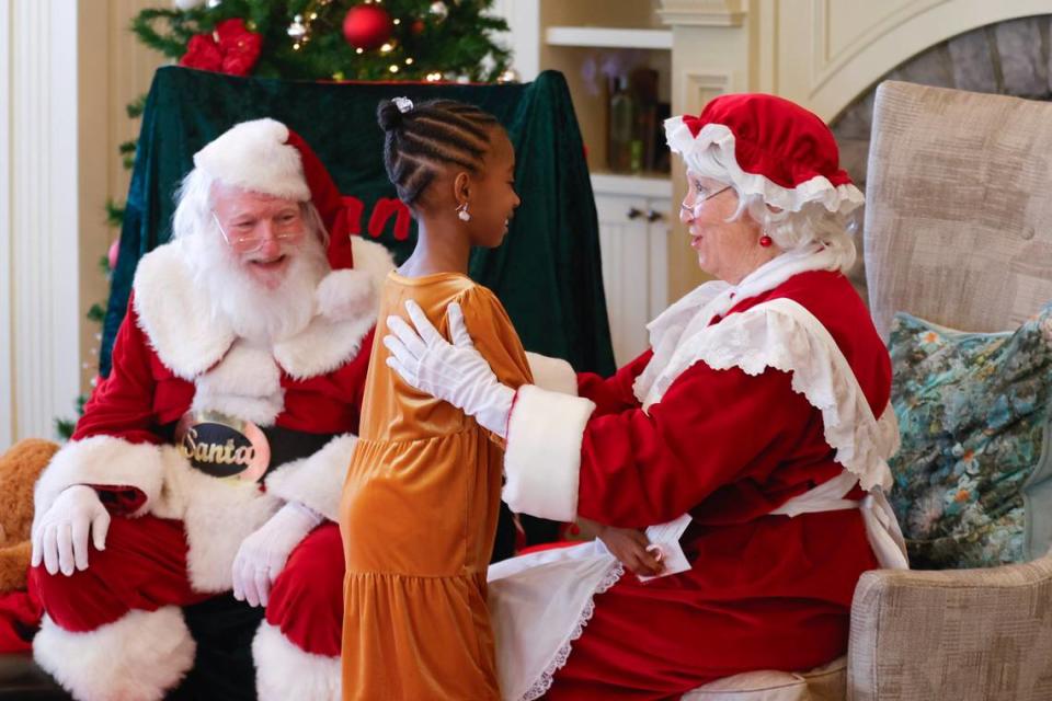 Jack and Trisha Senterfitt greet Kendall Prince, 7, dressed as Santa and Mrs. Claus in Stone Mountain on Tuesday, Nov. 21, 2023. (Natrice Miller/ Natrice.miller@ajc.com)