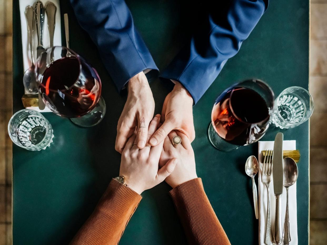 aerial shot of a couple holding hands on a dinner table