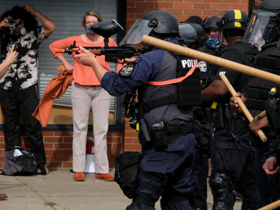 <p>Police officers face-off with BLM protestors marching in downtown Louisville</p>AFP via Getty Images