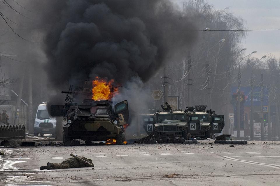 FILE - An armored personnel carrier burns and damaged Russian light utility vehicles stand abandoned after fighting in Kharkiv, Ukraine, on Feb. 27, 2022. The invasion of Ukraine begins, which Putin characterizes as a "special military operation" needed to protect Russia's security. (AP Photo/Andrew Marienko , File)
