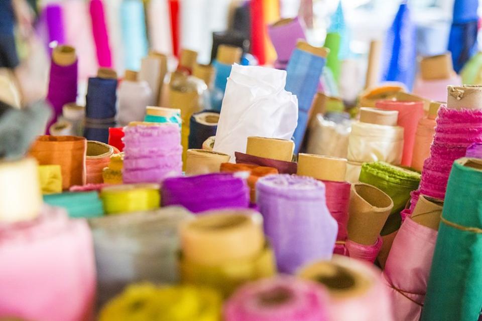 close up of assorted colorful and vibrant bolts of raw fabric material for sale in hagi lane textile shop in singapore