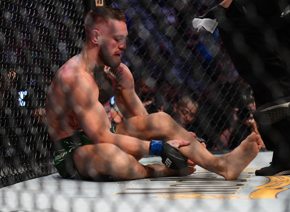 Jul 10, 2021; Las Vegas, Nevada, USA; Conor McGregor holds his leg after suffering an injury against Dustin Poirier during UFC 264 at T-Mobile Arena. Mandatory Credit: Gary A. Vasquez-USA TODAY Sports