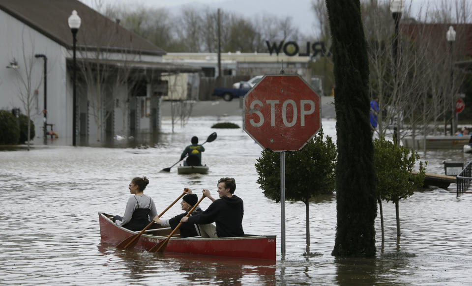 People paddle and row through the flooded Barlow Market District, Feb. 27, 2019, in Sebastopol, Calif. (Photo: Eric Risberg/AP)