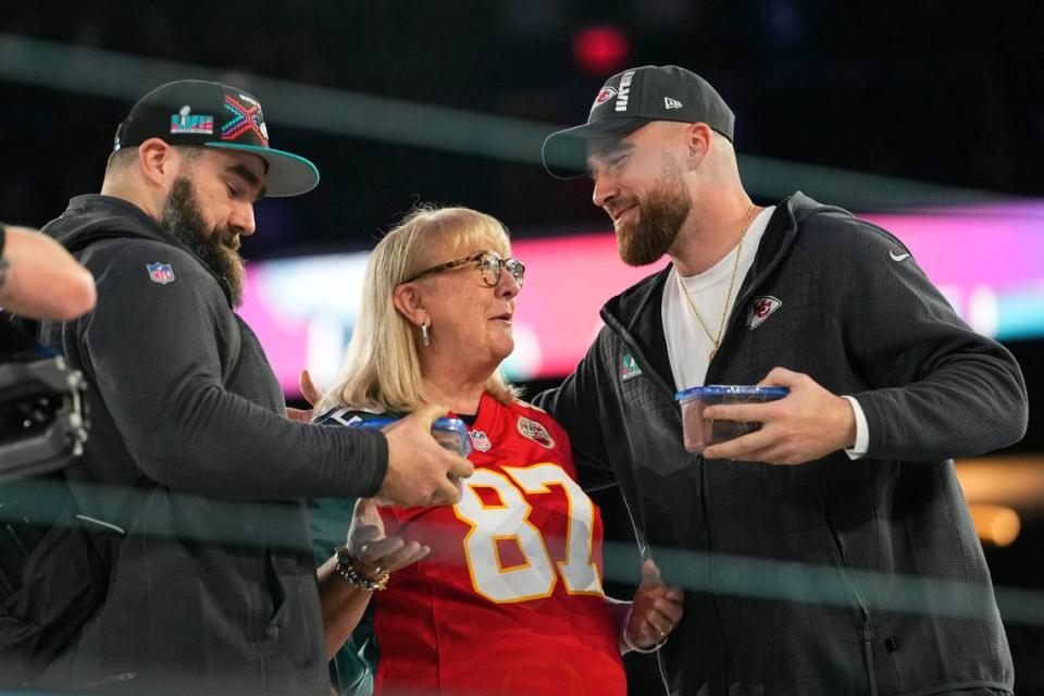 Donna Kelce greets her sons, Philadelphia Eagles center Jason Kelce, left, and Kansas City Chiefs tight end Travis Kelce during the Super Bowl Opening Night event in Phoenix.