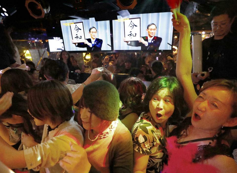 People celebrate as the countdown to new Emperor Naruhito's era of Reiwa, start, a few minutes before Wednesday, May 1, 2019, in Tokyo, Japan. Emperor Akihito announced his abdication at a palace ceremony Tuesday in his final address. The screens, rear, shows that Japan's Chief Cabinet Secretary Yoshihide Suga unveiled the name of new era "Reiwa." (Yohei Fukai/Kyodo News via AP)