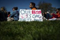 <p>Demonstrator sit next to a sign that reads “Our Blood Is On Their Hands” during a school walkout protesting the National Rifle Association (NRA) in Washington, D.C., on Friday, April 20, 2018. Students around the U.S. left school to take a moment of silence to honor the victims of the Columbine High School shooting, on its 19th Anniversary. (Photo: Al Drago/Bloomberg via Getty Images) </p>