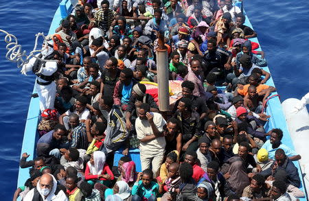 A group of 300 sub-Saharan Africans sit in board a boat during a rescue operation by the Italian Finance Police vessel Di Bartolo (not pictured) off the coast of Sicily, May 14, 2015. REUTERS/Alessandro Bianchi