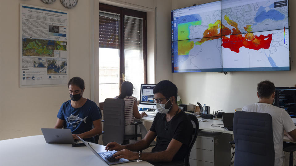 People work in the control rooms with displays of the CMCC (Euro-Mediterranean Center on Climate Change) in the background at an institute established to monitor and predict the effects of climate change on the Mediterranean region, in Lecce, Italy.