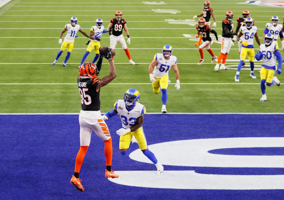 Tee Higgins #85 catches a touchdown pass from Joe Mixon #28 of the Cincinnati Bengals over Nick Scott #33 of the Los Angeles Rams during the second quarter of Super Bowl LVI at SoFi Stadium on February 13, 2022 in Inglewood, California.