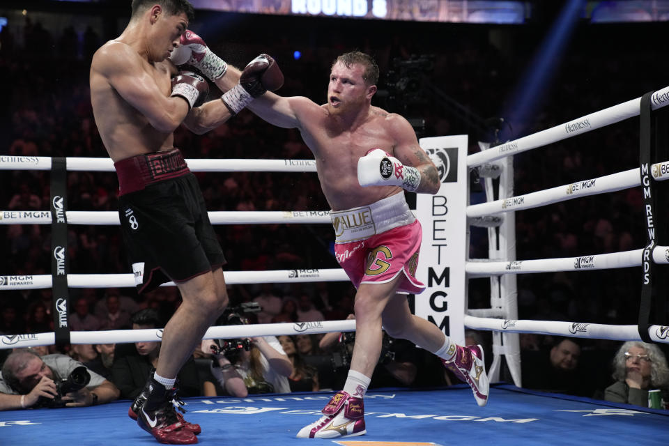 Canelo Alvarez, right, of Mexico, throws a punch against Dmitry Bivol, of Kyrgyzstan, during a light heavyweight title fight, Saturday, May 7, 2022, in Las Vegas. (AP Photo/John Locher)