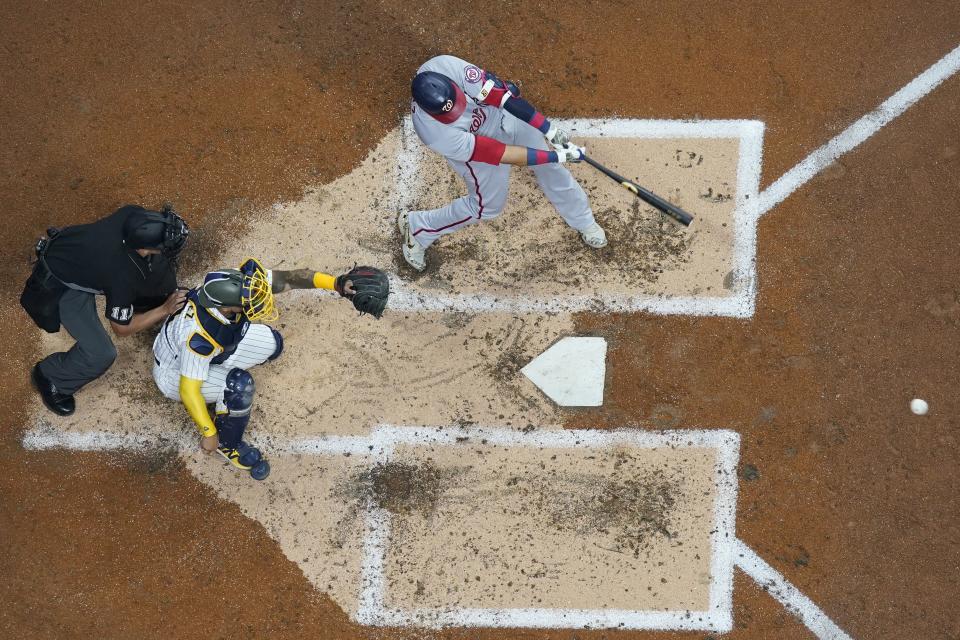 Washington Nationals' Nelson Cruz hits a single during the fourth inning of a baseball game against the Milwaukee Brewers Friday, May 20, 2022, in Milwaukee. (AP Photo/Morry Gash)