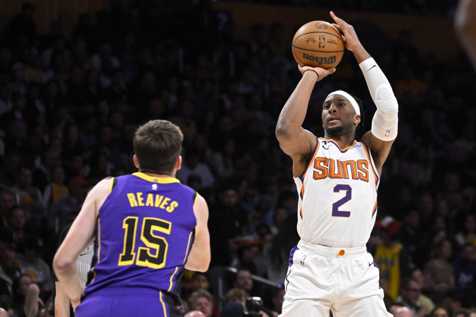 Phoenix Suns forward Josh Okogie, right, shoots as Los Angeles Lakers guard Austin Reaves defends during the first half of an NBA basketball game Friday, April 7, 2023, in Los Angeles. (AP Photo/Mark J. Terrill)