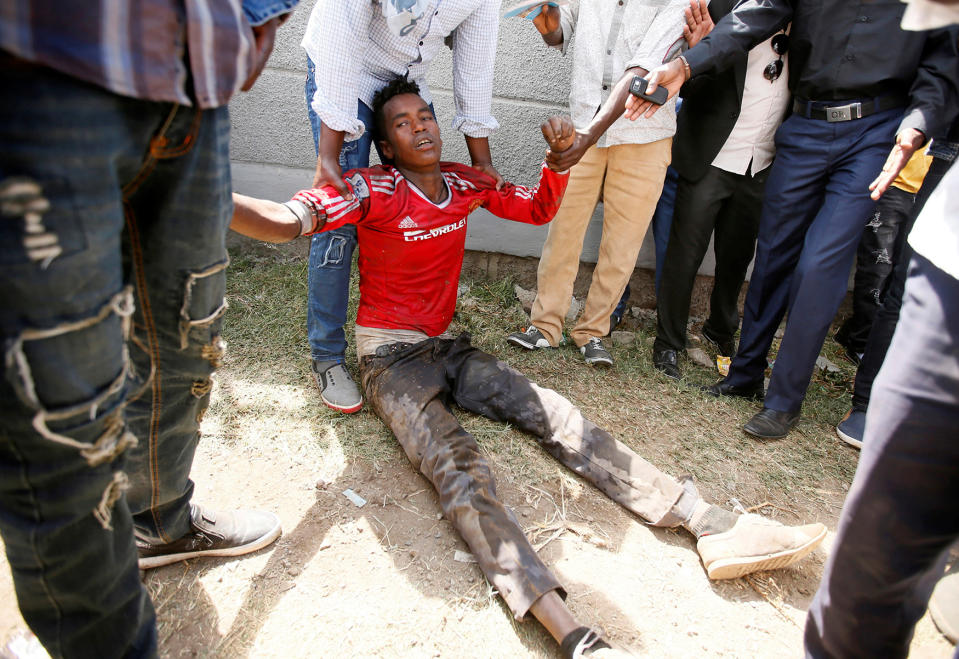 People assist an injured protestor during Irrechaa, the thanks giving festival of the Oromo people in Bishoftu town of Oromia region, Ethiopia