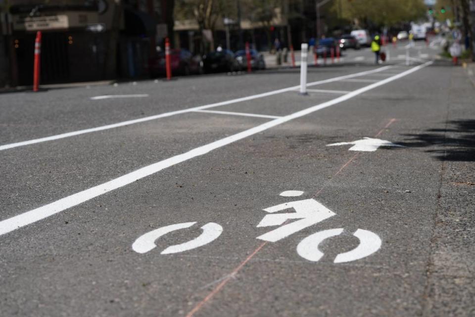 Crews began installing bike lanes on Holly Street between Ellis and Prospect on Wednesday, May 1, 2024, in downtown Bellingham, Wash. The install is part of a trial project designed to make travel in the area safer for people walking and cycling.
