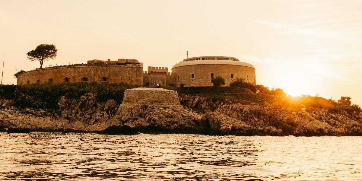 The fort on Mamula Island at sunset. The sun is seen in the background behind the fort.