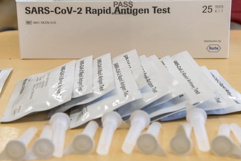 Rapid tests for the coronavirus lay on a desk in a class room at the Lyonel Feininger Gymnasium in Halle, Germany, Monday, March 22, 2021. For the first time, rapid tests are used by the pupils at the school on the initiative of the headmaster. (Holger John/dpa via AP)