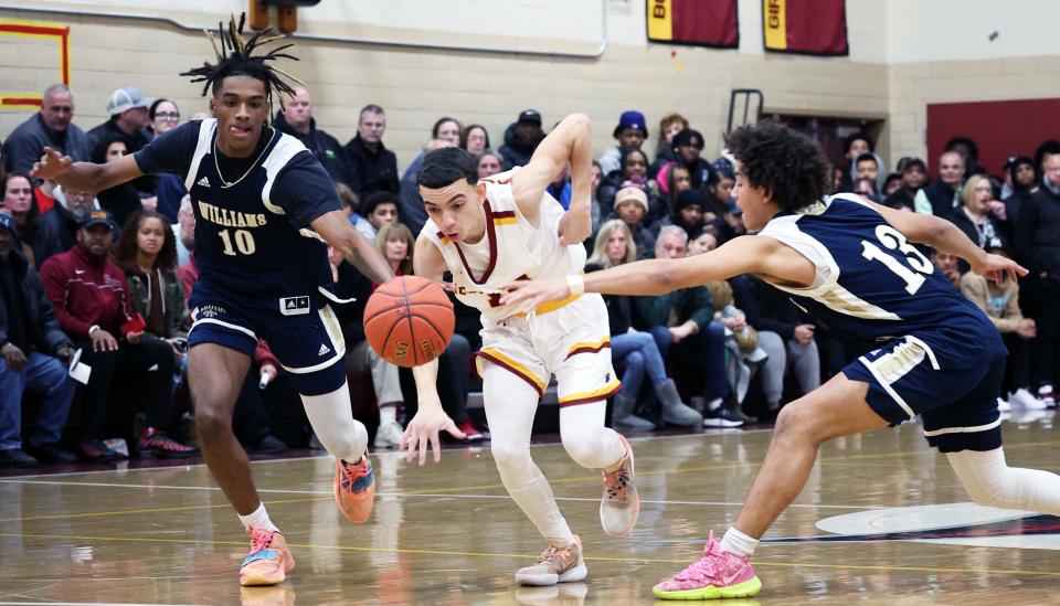 Cardinal Spellman's Jay' Von DePina dribbles the basketball through Archbishop Williams defenders from left, Andre Espaillat and Tristan Rodriguez during a game on Wednesday, Dec. 21, 2022.